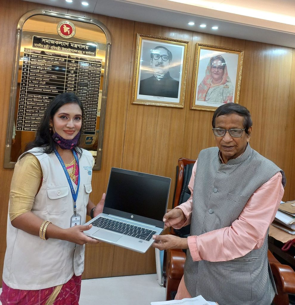 Office workers use laptops at shared desks during a collaborative working day.