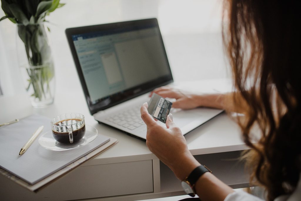 Buy Now, Pay Later Is Credit Wearing a Friendlier Coat A person shopping online with a credit card beside a laptop